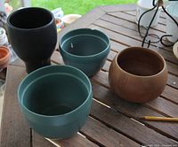 Top view of four glazed pots showing colours and openings
