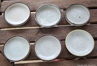 Top view of six speckled glazed saucers showing color and sizes
