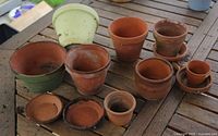 Top view of all 8 pots and 4 saucers on wooden table
