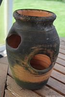 Front view showing two of the side planting holes and weathered terracotta surface