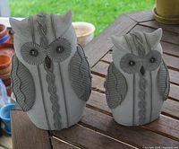 Front view of both fabric-covered owl figures showing size difference and decorative trim