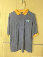Front view of navy polo with yellow collar, Blockbuster Video patch