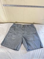 Front view of gray cargo shorts laid flat