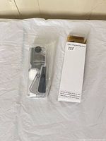 Grinder in plastic wrap beside original white box