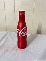 Front view of red aluminum Coca-Cola bottle