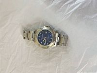 Front view showing blue dial, bezel, and bracelet