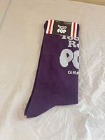 Folded purple socks with front tag showing Tootsie Roll Pop grape graphic