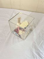 Acrylic cube containing loose vintage postage stamps