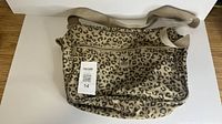 Front view displaying leopard print, logo patch, strap and zip pocket