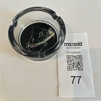 Top view of round glass ashtray showing skeleton graphic and cigarette rests