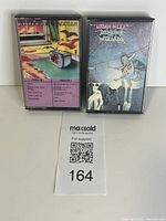 Front view of both cassette tapes in cases showing cover art