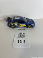 Side view of blue Subaru Impreza die-cast model showing graphics and wheels