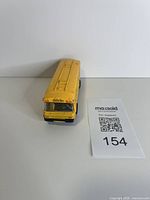 Front view of die-cast yellow school bus toy showing windshield label and overall condition
