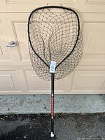 Full view of landing net against garage door