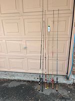 Full view of all fishing rods leaning on garage door