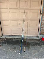 Four fishing rods leaning against garage door