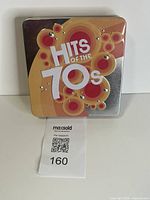 Front of metal tin showing Hits of the 70s graphic