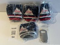 Four packaged Coors Light knit can koozies and one Smirnoff opener