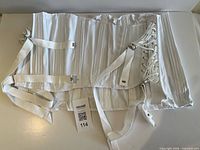 Front view of white lumbosacral corset with straps and lace-up side