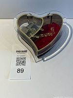 Top view showing heart-shaped box, clear lid, red velvet compartment, music mechanism, MaxSold card 89