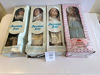 Four boxed porcelain dolls front view