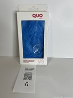 Front view of boxed Quo Beauty inflatable bath pillow showing item number card