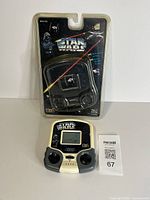 Handheld game displayed with opened blister card packaging