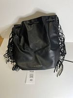 Front view of black Victoria’s Secret drawstring fringe bag