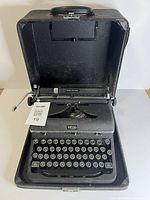 Typewriter seated in open carrying case showing full view