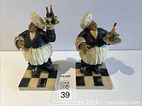 Front view of both resin chef statues on checkered bases