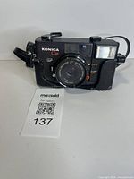 Front view of Konica C35 EF camera showing lens, flash and controls
