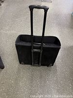 Rear view of suitcase showing telescoping handle, wheels and exterior fabric