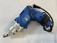 corded electric metal shear front and side view showing housing and cord