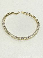 Full view of gold-tone tennis bracelet in closed circle