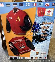 Front view of promotional display board showing jacket images, skier, logos and flags