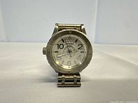 Front view of Nixon stainless steel wristwatch standing upright