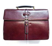 Front view of burgundy leather briefcase showing buckle strap and handle