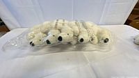 Front view of sealed bag containing six white Webkinz plush animals
