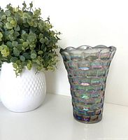 Full side view of the iridescent Yorktown Colonial vase next to a plant for scale