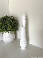 Full view of white milk glass hobnail swung vase standing upright
