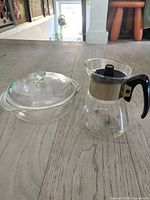 Carafe and covered casserole side by side on floor