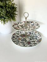 Full view of assembled two-tier cake stand showing pattern and metal handle