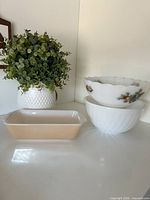 Front view showing all three milk glass pieces: peach lustre baking dish, white swirl bowl, Fruit de France bowl