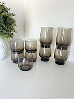 Group of nine smoky grey Dominion glasses, stacked to show size difference