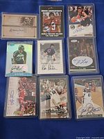 Overall view of nine autographed sports cards in protective cases