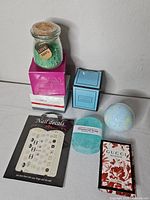 Group shot of entire lot showing bath salts jar, Vitale boxes, two candles, nail decals, soap, bath bomb, Gucci sample