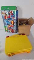 Exterior view showing Duplo Marvel box, yellow Lego case, cardboard box of bricks
