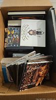 Cardboard box containing CDs, cassette tapes and other media