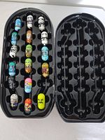 Open tin showing 19 Mighty Beanz in tray and empty slots