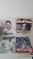 Four autographed photos in plastic sleeve: Dodgers portrait, Red Sox(?) #2 batting, Cubs pitcher, Tigers pitcher